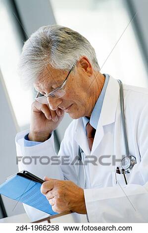 Stock Photo - Doctor with tablet in corridor, Onkologikoa Hospital, Oncology Institute, Case Center for prevention, diagnosis and treatment of cancer, Donostia, San Sebastian, Gipuzkoa, Basque Country, Spain. Fotosearch