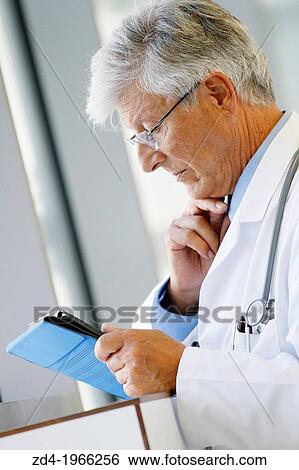 Stock Photograph - Doctor with tablet in corridor, Onkologikoa Hospital, Oncology Institute, Case Center for prevention, diagnosis and treatment of cancer, Donostia, San Sebastian, Gipuzkoa, Basque Country, Spain. Fotosearch