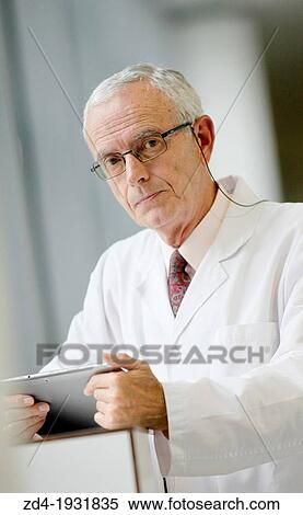 Stock Photography - Doctor with tablet in corridor, Onkologikoa Hospital, Oncology Institute, Case Center for prevention, diagnosis and treatment of cancer, Donostia, San Sebastian, Gipuzkoa, Basque Country, Spain. Fotosearch
