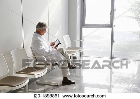 Stock Image - Doctor with tablet in waiting room, Onkologikoa Hospital, Oncology Institute, Case Center for prevention, diagnosis and treatment of cancer, Donostia, San Sebastian, Gipuzkoa, Basque Country, Spain. Fotosearch
