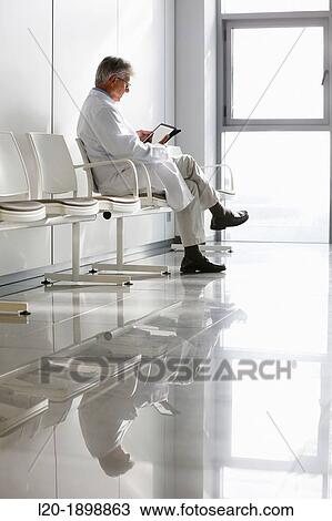 Stock Image - Doctor with tablet in waiting room, Onkologikoa Hospital, Oncology Institute, Case Center for prevention, diagnosis and treatment of cancer, Donostia, San Sebastian, Gipuzkoa, Basque Country, Spain. Fotosearch