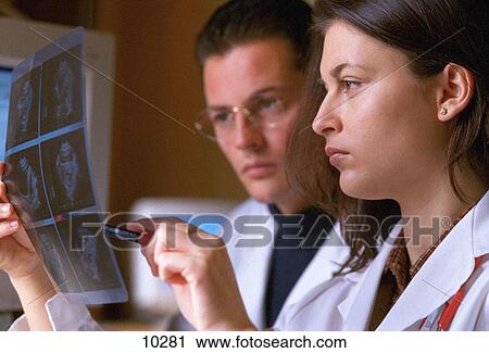 Doctors studying CAT (Computer Axial Tomography) scan results View Large Photo Image Stock Image - Doctors studying CAT (Computer Axial Tomography) scan results. Fotosearch