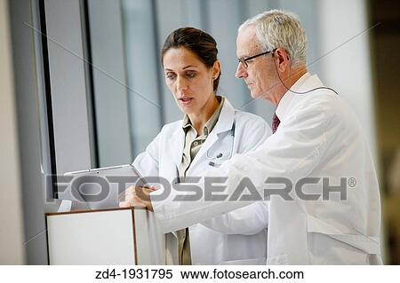 Stock Photography - Doctors with tablet in corridor, Onkologikoa Hospital, Oncology Institute, Case Center for prevention, diagnosis and treatment of cancer, Donostia, San Sebastian, Gipuzkoa, Basque Country, Spain. Fotosearch