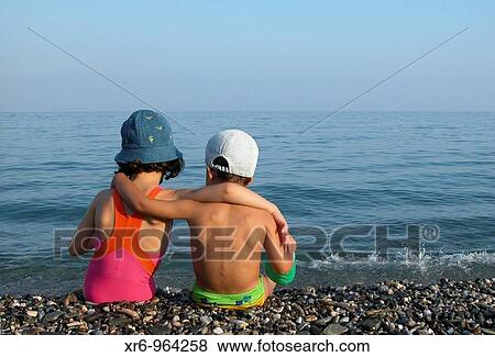 Stock Photo - Dos nios juegan en una playa de Granada. Fotosearch