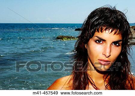 Drak-haired young woman on beach View Large Photo Image Stock Photo - Drak-haired young woman on beach. Fotosearch