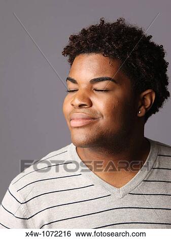 Dreamy young African-American man posing for portrait View Large Photo Image Stock Photograph - Dreamy young African-American man posing for portrait. Fotosearch