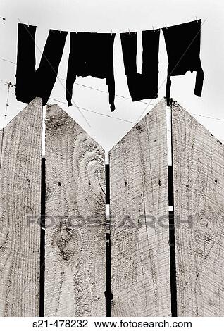 Drying clothes can be seen secretly hanging behind a wooden, picket fence. View Large Photo Image Stock Image - Drying clothes can be seen secretly hanging behind a wooden, picket fence.. Fotosearch