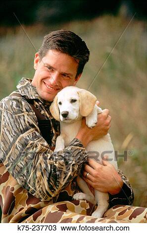 Stock Image - Duck hunter bonding with his new pup. Fotosearch
