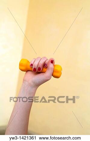 Stock Image - Dumbbell in hand - fitness working out exercise health Indoors. Fotosearch