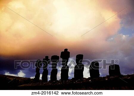 Stock Image - EASTER ISLAND, ANAKENA BEACH, AHU NAUNAU, MOAI STATUES SILHOUET- TED AT SUNRISE.. Fotosearch