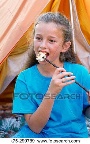 Stock Photo - eating a marshmallow at camp. Fotosearch