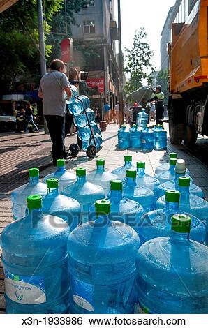 Economy size water bottles being unloaded from a truck in Santiago, Chile View Large Photo Image Stock Photograph - Economy size water bottles being unloaded from a truck in Santiago, Chile. Fotosearch