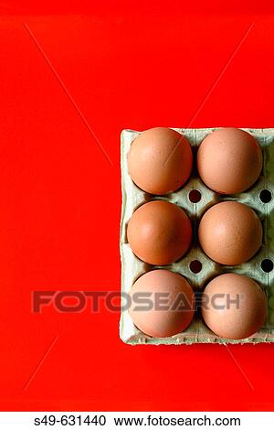 Stock Image - Eggs on red background. Fotosearch