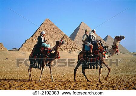 EGYPT. CAIRO. GIZEH. TWO CAMEL RIDERS AT FOOT OF THE PYRAMIDS. FEMALE TOURIST AS A PASSENGER (MR). View Large Photo Image Stock Image - EGYPT. CAIRO. GIZEH. TWO CAMEL RIDERS AT FOOT OF THE PYRAMIDS. FEMALE TOURIST AS A PASSENGER (MR).. Fotosearch