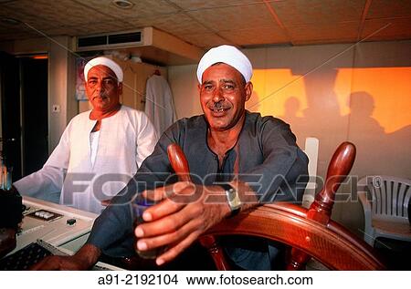 EGYPT. NUBIA. CRUISE ON LAKE NASIR. THE "RAIS" (CAPTAIN) AT WHEEL ON SUNRISE. View Large Photo Image Picture - EGYPT. NUBIA. CRUISE ON LAKE NASIR. THE "RAIS" (CAPTAIN) AT WHEEL ON SUNRISE.. Fotosearch