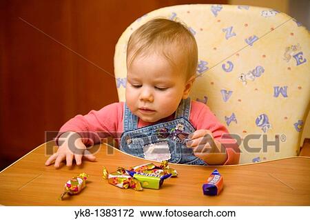 Eight Month Old Infant Girl Playing with Candy in High Chair View Large Photo Image Stock Image - Eight Month Old Infant Girl Playing with Candy in High Chair. Fotosearch