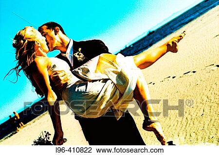 elated groom carrying bride and kissing after wedding ceremony View Large Photo Image Stock Image - elated groom carrying bride and kissing after wedding ceremony. Fotosearch