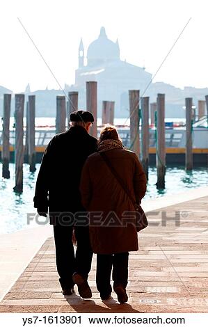 Stock Image - Elder couple walking at Zattere promenade in Venice, Italy, Europe. Fotosearch