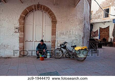 Elder man sitting at a house doorway in Essaouira medina, Morocco. View Large Photo Image Stock Image - Elder man sitting at a house doorway in Essaouira medina, Morocco.. Fotosearch