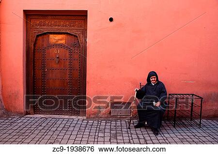 Stock Photograph - Elder man sitting in Marrakech medina, Morocco.. Fotosearch
