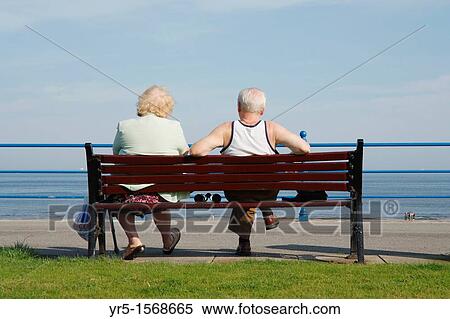 Stock Photography - Elderly couple looking out to sea on sunny day at Seaton Carew near Hartlepool on the north east coast of England, United Kingdom. Fotosearch