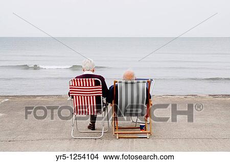 Elderly couple on deckchairs at the coast Whitby, North Yorkshire, England View Large Photo Image Picture - Elderly couple on deckchairs at the coast Whitby, North Yorkshire, England. Fotosearch