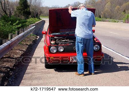 Elderly man checks under the hood for a car problem along the road View Large Photo Image Stock Photo - Elderly man checks under the hood for a car problem along the road. Fotosearch
