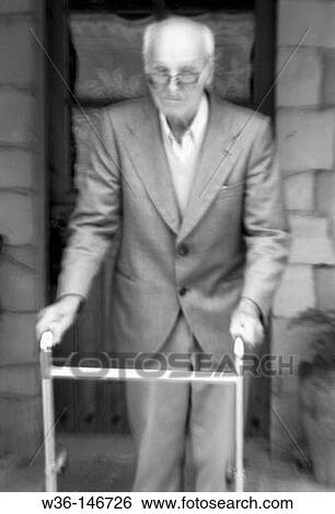Elderly man with a walking frame View Large Photo Image Stock Photograph - Elderly man with a walking frame. Fotosearch