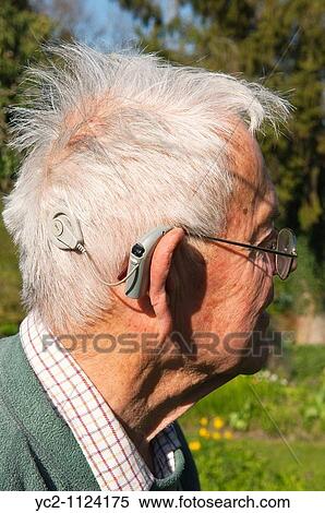 Stock Photography - Elderly man with his cochlear implant hearing aid in England, Great Britain, Uk. Fotosearch