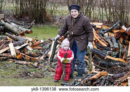 Elderly Senior Grandmother with Kid Girl Stacking and Loading Firewood View Large Photo Image Stock Photo - Elderly Senior Grandmother with Kid Girl Stacking and Loading Firewood. Fotosearch
