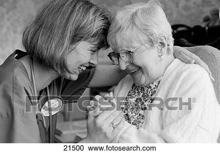 Stock Image - Elderly woman in nursing home with health care provider. Fotosearch