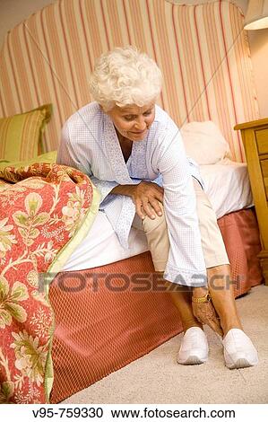 Elderly woman putting her slippers on View Large Photo Image Stock Image - Elderly woman putting her slippers on. Fotosearch