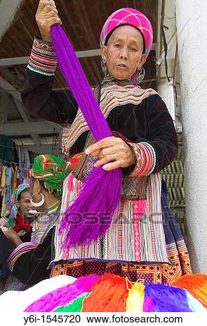 Stock Image - Elderly woman sorts yarn Bac Ha hilltribe market known for colourful Flower Hmong traders north Vietnam. Fotosearch