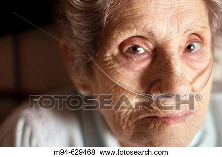 Stock Photo - Elderly woman using a nasal oxygen cannula. Fotosearch