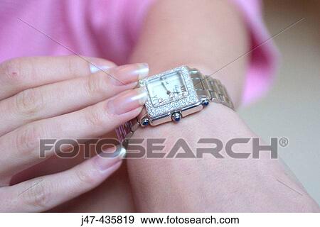 Stock Photo - Elegant hands touching a diamond encrusted watch. Fotosearch