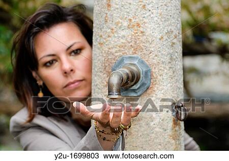 Elegant woman with a water well and touching the water with her hand View Large Photo Image Stock Image - Elegant woman with a water well and touching the water with her hand. Fotosearch