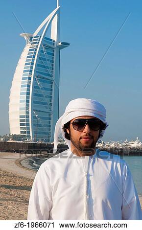 Emirate arab man in front of Worlds only 7 star hotel in Dubai UAE called the Burj Al Arab with luxury and water at beach in United Arab Emirates. View Large Photo Image Stock Image - Emirate arab man in front of Worlds only 7 star hotel in Dubai UAE called the Burj Al Arab with luxury and water at beach in United Arab Emirates.. Fotosearch