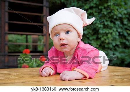 Emotional three month old baby girl on wooden table View Large Photo Image Stock Image - Emotional three month old baby girl on wooden table. Fotosearch