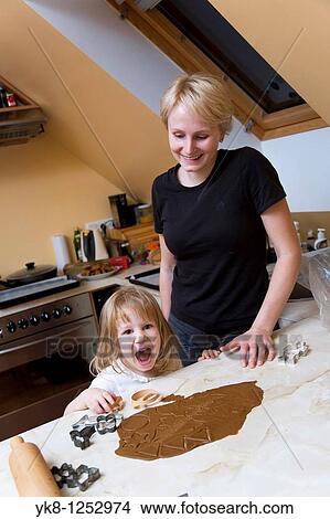 Emotional Two Years Old Girl with Mother Cooking Gingerbread View Large Photo Image Picture - Emotional Two Years Old Girl with Mother Cooking Gingerbread. Fotosearch