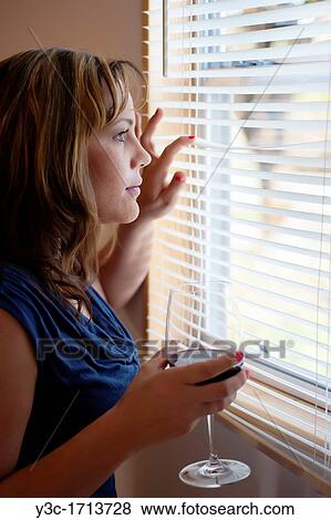 Stock Photo - Emotional woman looking out of a window. Fotosearch