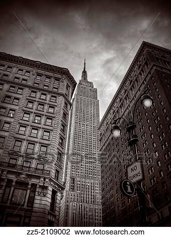 Empire state building between two buildings and lamp post. View Large Photo Image Stock Image - Empire state building between two buildings and lamp post.. Fotosearch