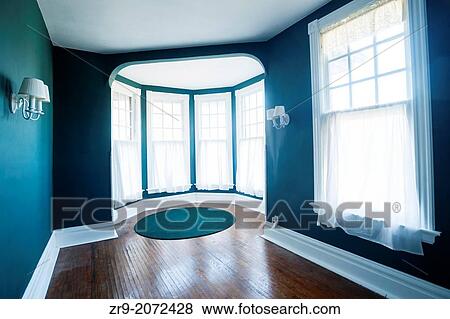 Stock Photo - Empty room with 5 windows, sconces, and wood flooring inside a Tudor home, USA.. Fotosearch