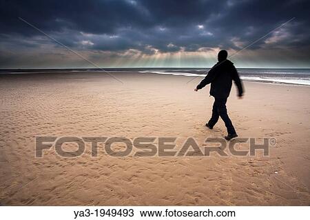 England, Lancashire, Blackpool. Hiker walking along the South Shore beach with distant storm above the Irish Sea. View Large Photo Image Stock Image - England, Lancashire, Blackpool. Hiker walking along the South Shore beach with distant storm above the Irish Sea.. Fotosearch