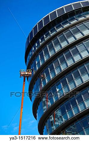 England, London, Southwark Workman performing maintenance from a cherry picker on a window of the London City Hall located near Tower Bridge on the River Thames View Large Photo Image Stock Photograph - England, London, Southwark Workman performing maintenance from a cherry picker on a window of the London City Hall located near Tower Bridge on the River Thames. Fotosearch