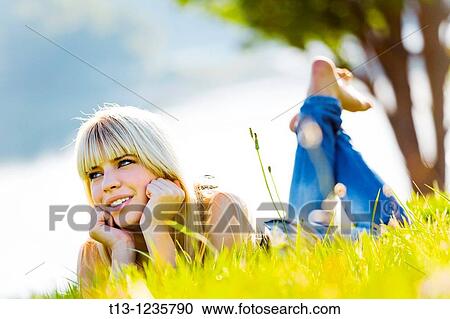 Enjoying sun teen girl is lying on the grass View Large Photo Image Stock Image - Enjoying sun teen girl is lying on the grass. Fotosearch