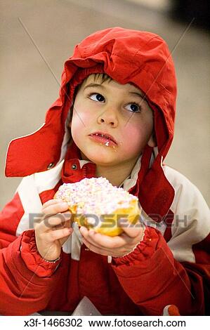Enraptured Boy age 5 eating a frosted doughnut St Paul Minnesota MN USA View Large Photo Image Stock Image - Enraptured Boy age 5 eating a frosted doughnut St Paul Minnesota MN USA. Fotosearch