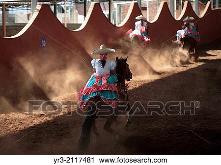 Stock Image - Escaramuzas ride their horses in an Escaramuza fair in the Lienzo Charros el Penon, Mexico City, Sunday, January 19, 2013.. Fotosearch