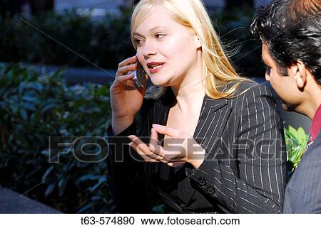 ethnic business man looking at 25 yr old caucasian business woman on cell phone View Large Photo Image Stock Image - ethnic business man looking at 25 yr old caucasian business woman on cell phone. Fotosearch
