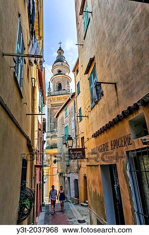 Stock Photo - Europe, France, Alpes-Maritimes, Menton. Couple of tourists walking in the old town.. Fotosearch