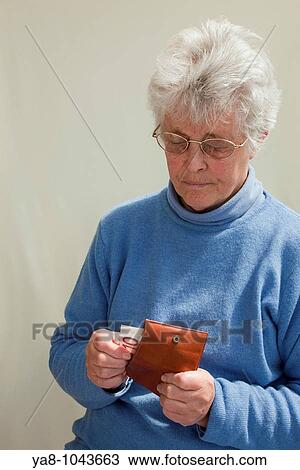 Europe Senior woman pulling ten Euro note from a purse looking worried MR 09/05 View Large Photo Image Stock Image - Europe Senior woman pulling ten Euro note from a purse looking worried MR 09/05. Fotosearch